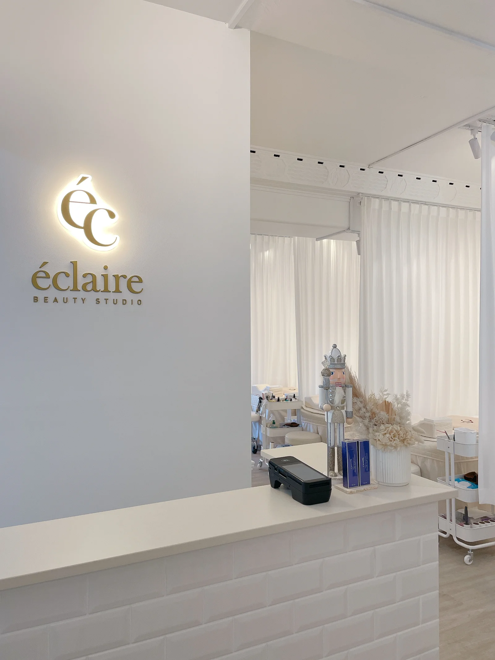 Backlit gold éc monogram sign on the white reception wall